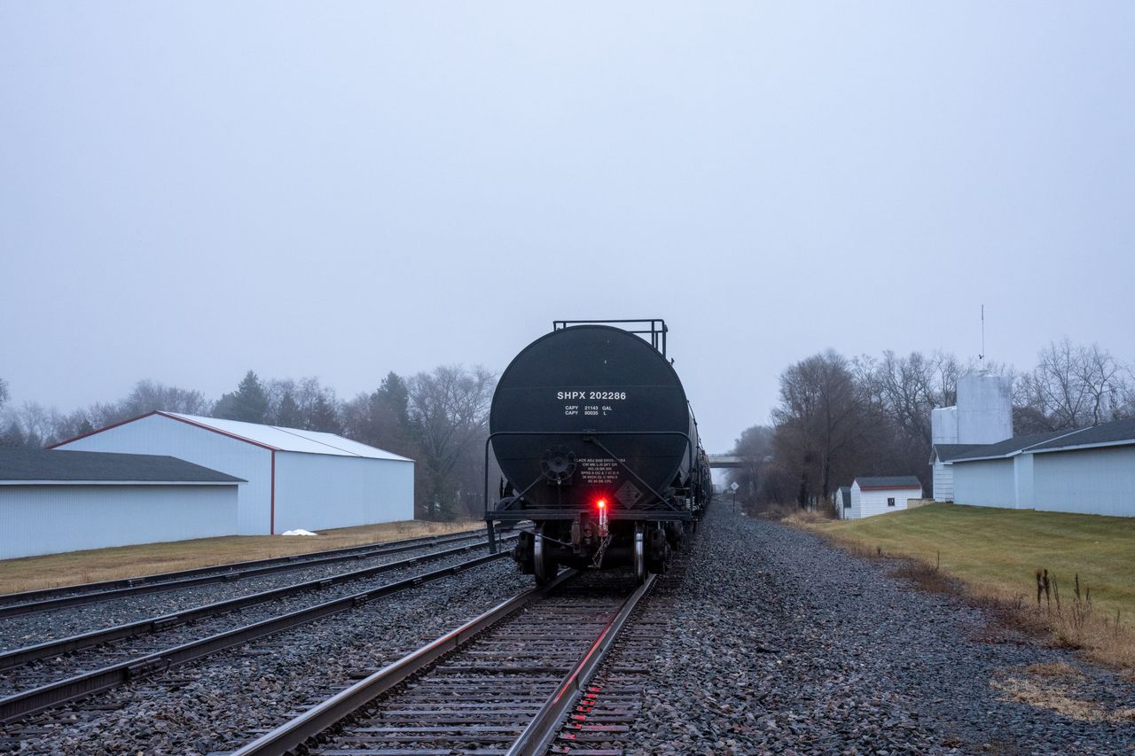 About Lone freight train car on railway tracks in misty Wabasha, Minnesota during daytime.
